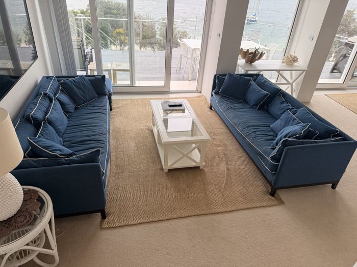 Living room with navy sofas opening onto the deck at Riviera