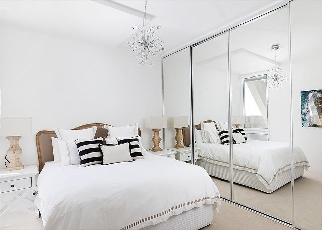 Bedroom with a large bed and mirrored wardrobes