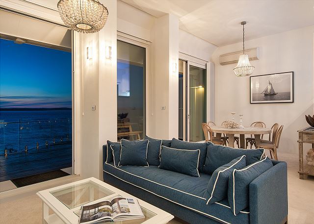 Open-plan living room with navy sofas and water views
